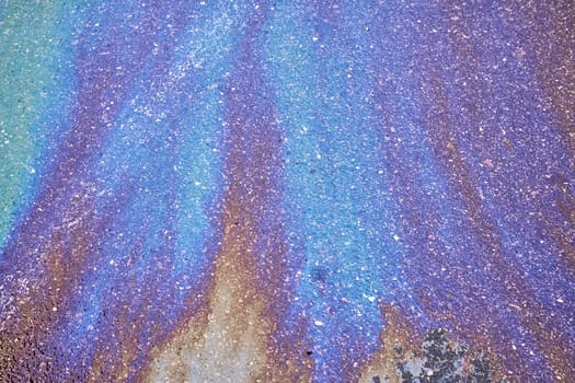 Colorful oil slick on an asphalt background, creating an eye-catching and dynamic scene