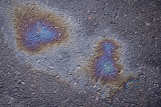 Asphalt oil stain, colorful gasoline spills on the road surface as a texture or background.