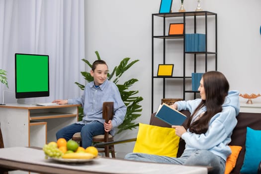 A warm and cozy home environment showcasing a boy and a girl happily interacting with books and modern technology