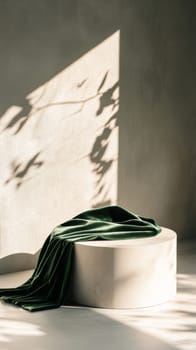 Sunlit shadow with green velvet on round pedestal, minimalist concept.