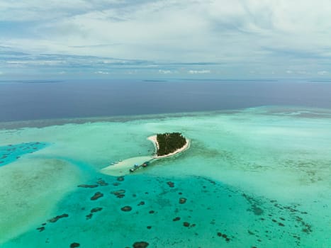 Aerial view of tropical island with palm trees and sandy beach. Onok Island, Balabac, Philippines.