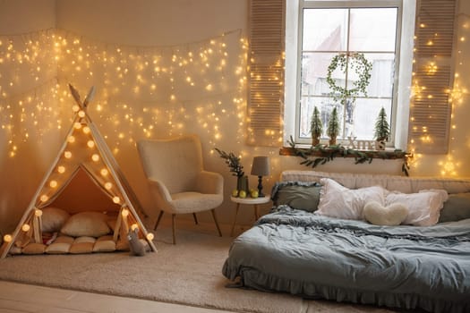 Christmas at home in scandinavian style, cozy room with bed and children's tent, decorated with new year garlands and tree
