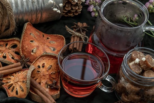 Hot bael fruit tea with bark of bael fruit and brown cane sugar cube. The properties of hot bael fruit juice is a kind of herb - The concept of health. Drinks & Beverages, Selective Focus.