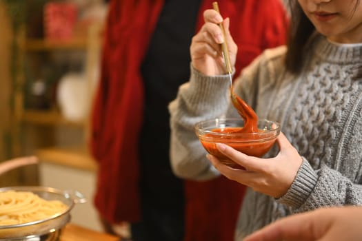 Young woman preparing spaghetti for a festive Christmas dinner.