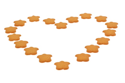 A vibrant heart shape is beautifully crafted from delicious starshaped cookies against a clean, simple background