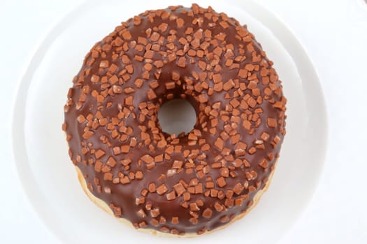 Enjoy a chocolate glazed donut topped with crunchy, colorful sprinkles, ideal for all dessert lovers