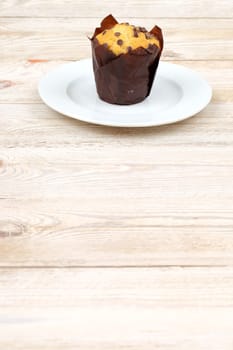 A tempting muffin is beautifully displayed on a clean white plate, perfect for bakery and dessert themes