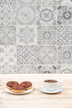 A delightful coffee and delectable donuts setup is beautifully arranged against a stylish patterned backdrop