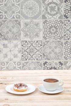 Enjoy a cozy breakfast with a steaming cup of coffee and a delicious donut against a stylish tile backdrop