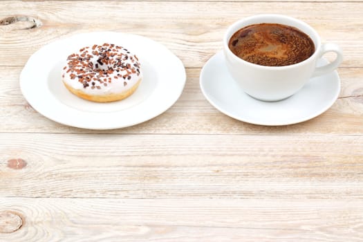 Indulge in a delicious donut topped with chocolate sprinkles, served perfectly alongside a warm cup of coffee