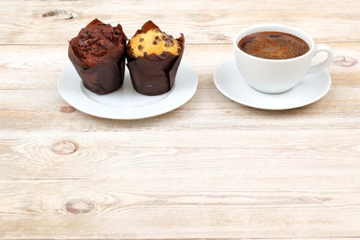 A cozy scene with two delightful muffins and a steaming cup of rich coffee, ideal for breakfast or a snack