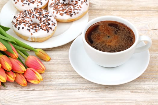 Take a moment to savor a delightful coffee break while enjoying some delicious donuts and bright, cheerful tulips