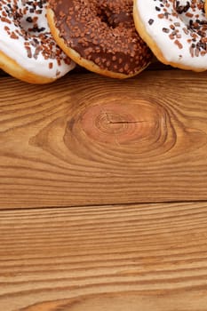 An enticing and visually appealing image showcasing chocolate and icingcovered donuts on a rustic wooden surface