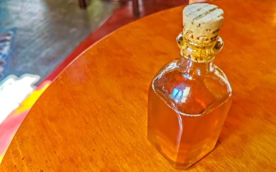 olive oil bottle dispenser on wooden table in Zicatela Puerto Escondido Oaxaca Mexico.