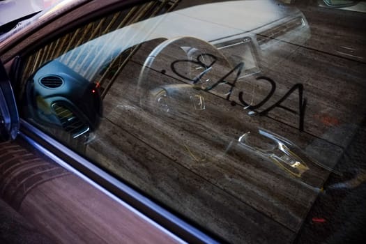 Cremona, Itally - October 6th 2024 Contemporary car interior with wooden fence reflection, featuring steering wheel, gear stick, and dashboard