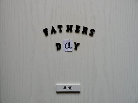 Lettering father in black letters on grey background on father's day close-up