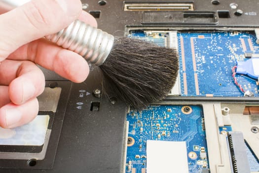 Cleaning the notebook system with a brush during maintenance.