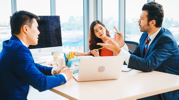 Smart businessman and businesswoman talking discussion in group meeting at office table in a modern office interior. Business collaboration strategic planning and brainstorming of coworkers. Jivy