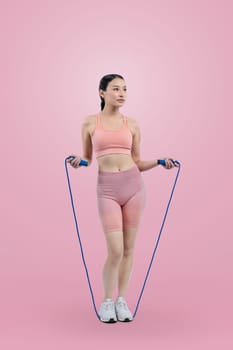 Young energetic asian woman in sportswear with jumping or skipping robe posing portrait in studio shot on isolated background. Cardio exercise tool and healthy body care lifestyle. Vigorous