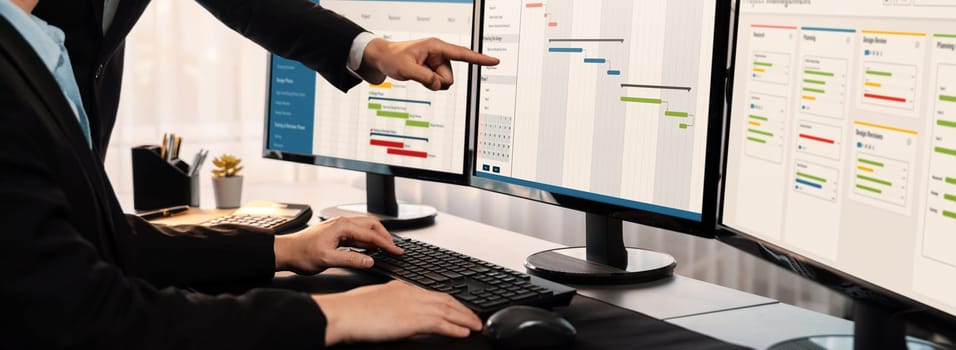 Project management team coordinating and update project planned schedule on computer using Gantt chart software in office. Business people planning time and deadline for company task. Trailblazing