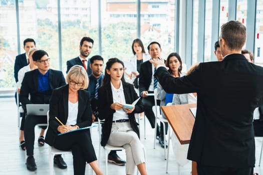 Group of business people meeting in a seminar conference . Audience listening to instructor in employee education training session . Office worker community summit forum with expert speaker . Jivy