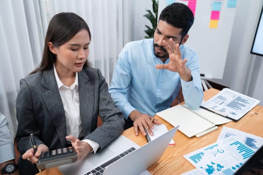 Multiracial analyst team use BI dashboard data to analyze financial report on meeting table. Group of diverse business people utilize data analysis by FIntech for business marketing decision. Concord