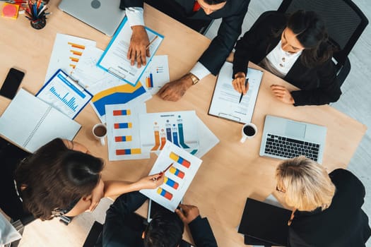 Business people group meeting shot from top view in office . Profession businesswomen, businessmen and office workers working in team conference with project planning document on meeting table . Jivy