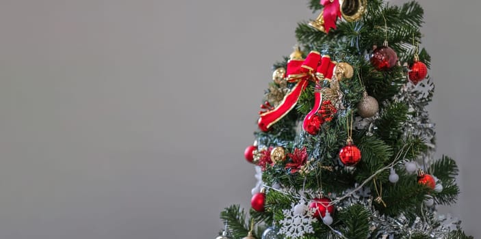 Christmas tree decorated with Golden balls toys on a blurred, sparkling and fabulous fairy background with beautiful bokeh, copy space..