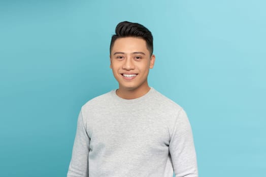 Attractive young handsome smiling face positive asian over blue background