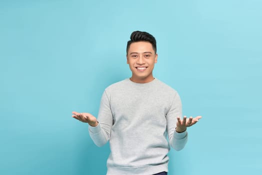 Friendly businessman with welcoming gesture isolated on blue background