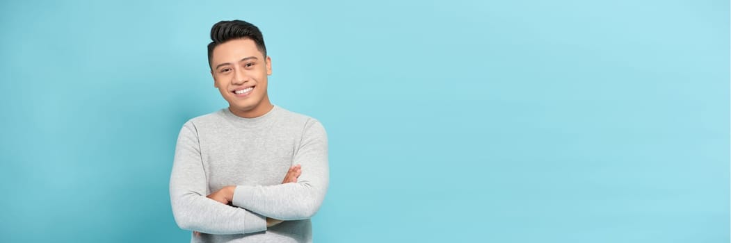 Banner of young asian man smiling happy at the camera with arms crossed