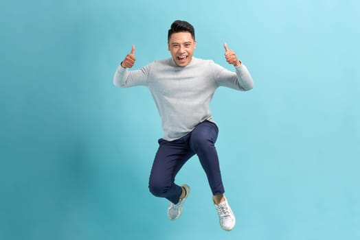 Full length photo of confident pretty man jumping high thumbs up empty space