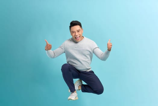 Portrait of young male cheerful confident and excited jump in air and smile in studio.