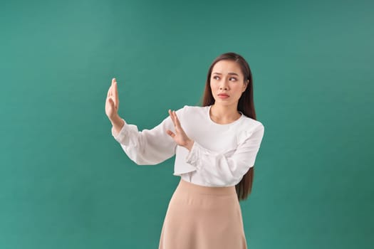 Stop. Concerned Asian woman showing refusal sign, saying no, raise awareness