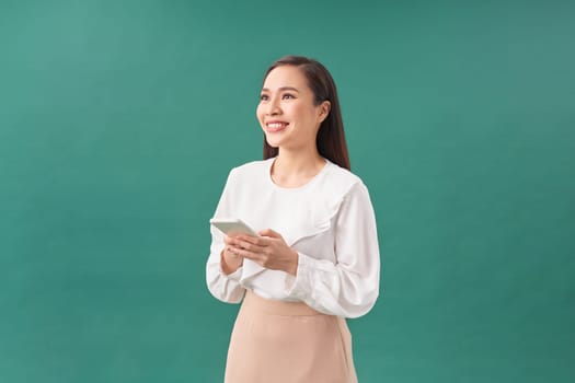 Young asian girl using smartphone typing message smiling with a happy and cool smile on face