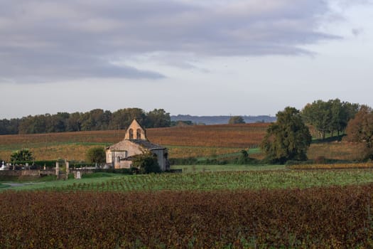 FRANCE, GIRONDE, ENTRE DEUX MERS VINEYARDS, CHURCH WITH AUTUMN COLORS. High quality photo