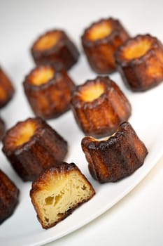 Caneles de bordeaux, traditional French sweet dessert with white table background, High quality photo