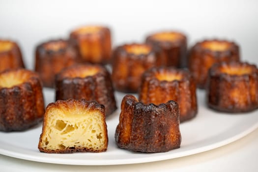 Caneles de bordeaux, traditional French sweet dessert with white table background, High quality photo
