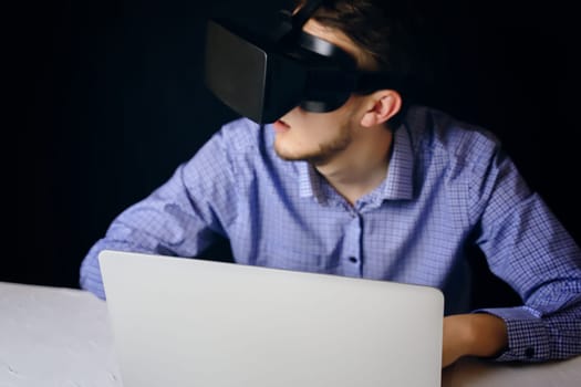 A person uses virtual reality on a laptop, blending technology with productivity and innovation in a modern workspace