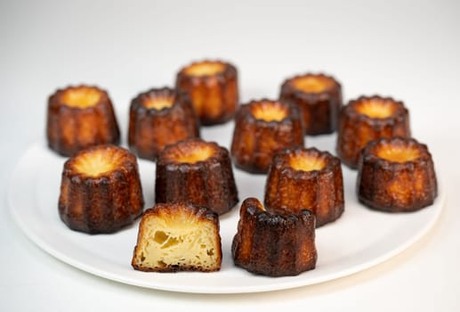 Caneles de bordeaux, traditional French sweet dessert with white table background, High quality photo