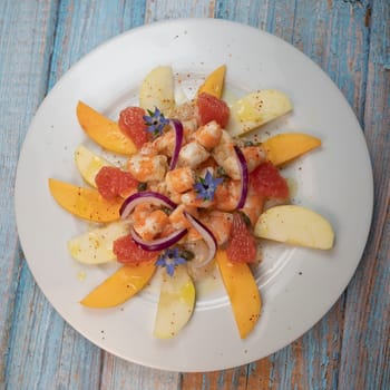 RECIPE CEVICHE OF SHRIMPS AND SCALLOPS WITH CITRUS FRUIT, LEMON, LIME, SQUEEZED ORANGE, GRAPEFRUIT AND FRUIT, PERSIMMON, APPLE, SEASONED WITH ESPELETTE PEPPER. High quality photo
