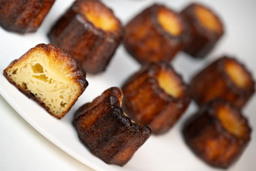 Caneles de bordeaux, traditional French sweet dessert with white table background, High quality photo