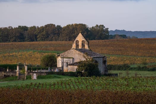 FRANCE, GIRONDE, ENTRE DEUX MERS VINEYARDS, CHURCH WITH AUTUMN COLORS. High quality photo
