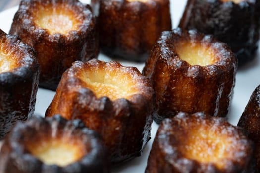 Caneles de bordeaux, traditional French sweet dessert with white table background, High quality photo