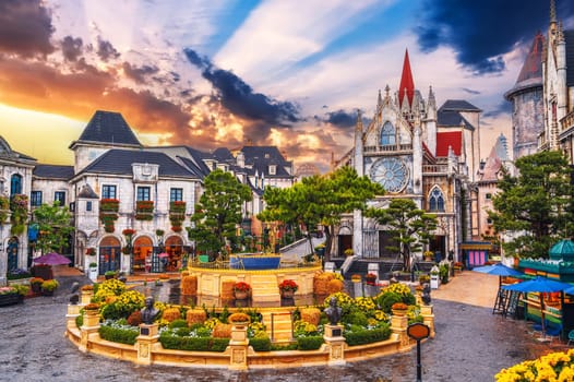 Catholic cathedral on square in the French village in Ba Na Hills Park in Da Nang in Vietnam at sunset