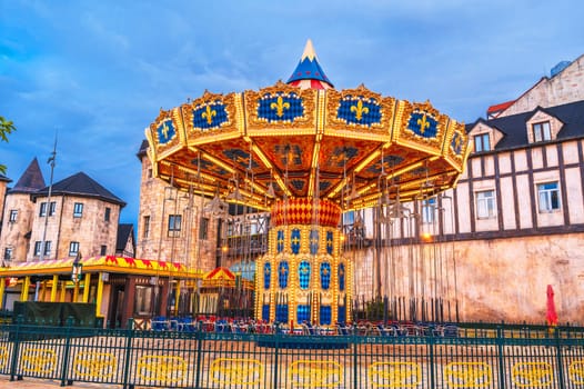 Festive chain carousel on the square of a medieval city in Europe