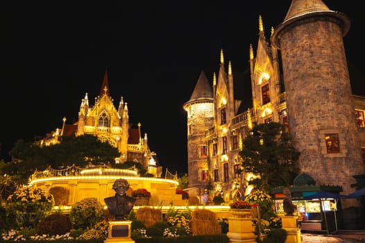 Catholic Cathedral and stone castle on central square of the medieval city in Ba Na Hills Park in Da Nang in Vietnam at night