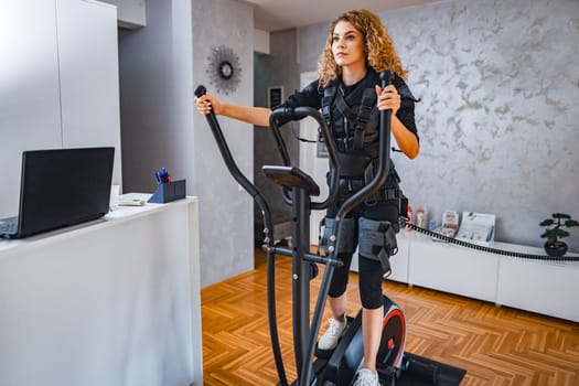 A woman engages in strength training with advanced technology at a gym.