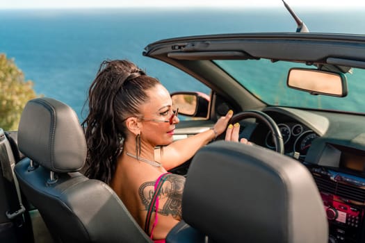 A woman is driving a red convertible with her hair in a ponytail. She is wearing a pink dress and is smiling