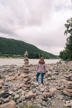 Woman at the river Katun at summer day. Trip on Altai Mountains in Altai Republic